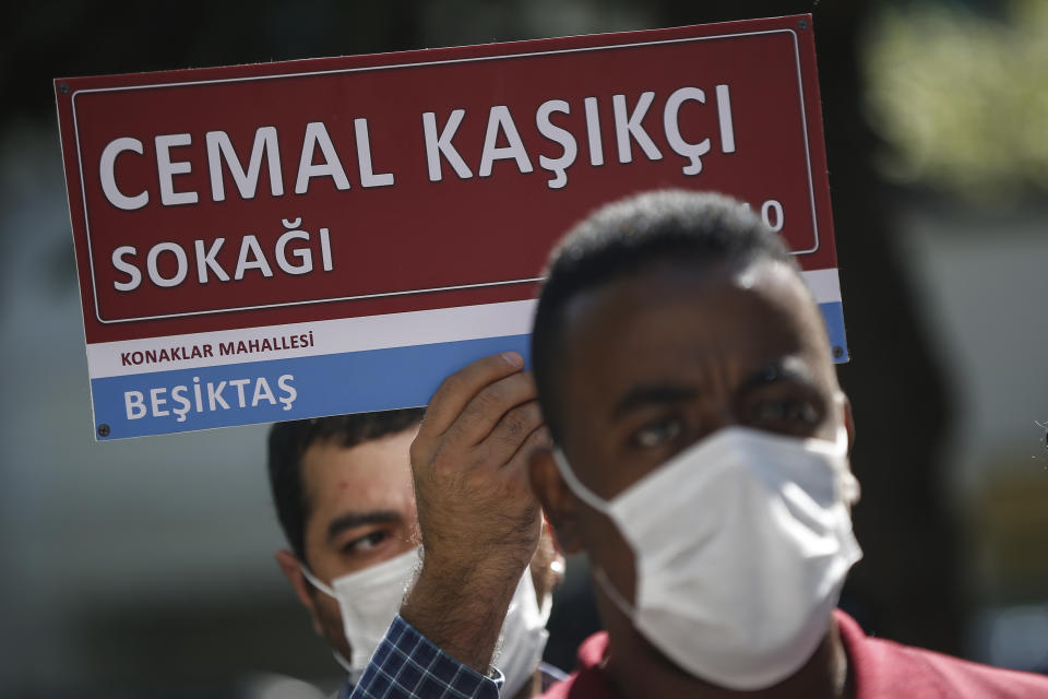 A man, holding an unofficial street sign reading in Turkish: 'Jamal Khashoggi Street', participates in an event near the Saudi Arabia consulate in Istanbul, marking the two-year anniversary of his death, Friday, Oct. 2, 2020. The gathering was held outside the consulate building, starting at 1:14 p.m. (1014 GMT) marking the time Khashoggi walked into the building where he met his demise. (AP Photo/Emrah Gurel)