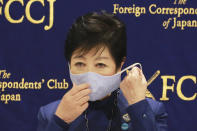 Tokyo Gov. Yuriko Koike takes off her mask as she speaks at a news conference in Tokyo, Tuesday, Nov. 24, 2020. Koike remains firm about being able to safely hold the Olympics next year despite growing concerns about Japan's recent resurgence of COVID-19 infections. (AP Photo/Koji Sasahara)