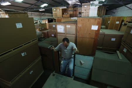 Jhousi Oliveros, 36, inspects the main storage room of Clover International, one of Venezuela's biggest moving companies, in Caracas July 9, 2014.