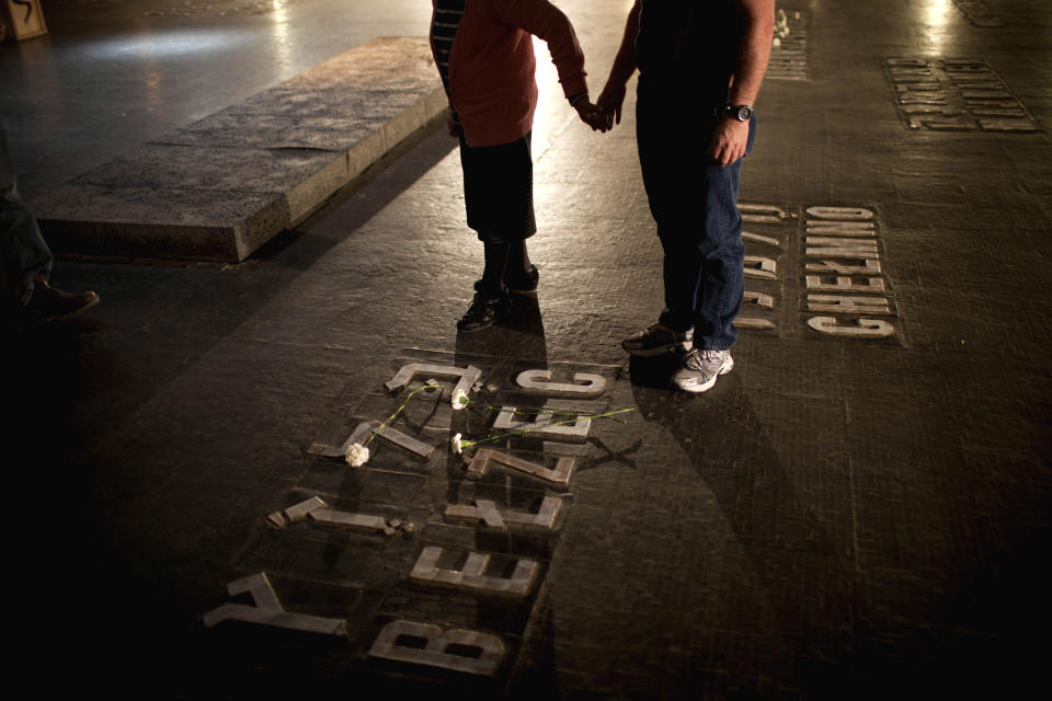 Relatives of Holocaust victims lay flowers next to the names of concentration camps during a ceremony marking the annual Holocaust Remembrance Day at the Yad Vashem Holocaust Memorial in Jerusalem, Monday, April 8, 2013. (AP Photo/Oded Balilty)