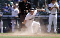 Seattle Mariners' Jarred Kelenic, center front, scores on a double by teammate Kyle Lewis against the Oakland Athletics during the fourth inning of a baseball game, Monday, May 31, 2021, in Seattle. (AP Photo/John Froschauer)