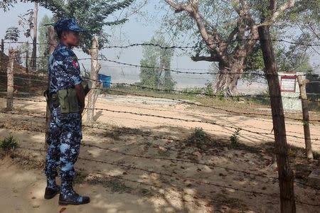 A Myanmar policeman stands outside of a camp set up by Myanmar's Social Welfare, Relief and Resettlement Minister to prepare for the repatriation of displaced Rohingyas, who fled to Bangladesh, outside Maungdaw in the state of Rakhine, Myanmar January 24, 2018. REUTERS/Stringer