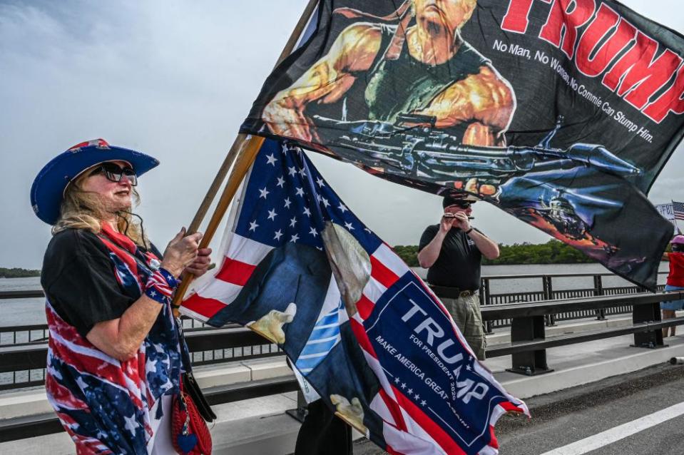 woman waves flag with trump as an action hero