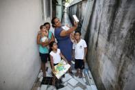 Jaqueline (C), 25, holds her five-month-old daughter Laura, as she takes a selfie with her children Gabrielle (2nd L), 4, and Paulo (R), 8, and her mother Manyara (L), 46, who holds five-month-old Lucas in front of their house in Santos, Sao Paulo state, Brazil April 20, 2016. REUTERS/Nacho Doce