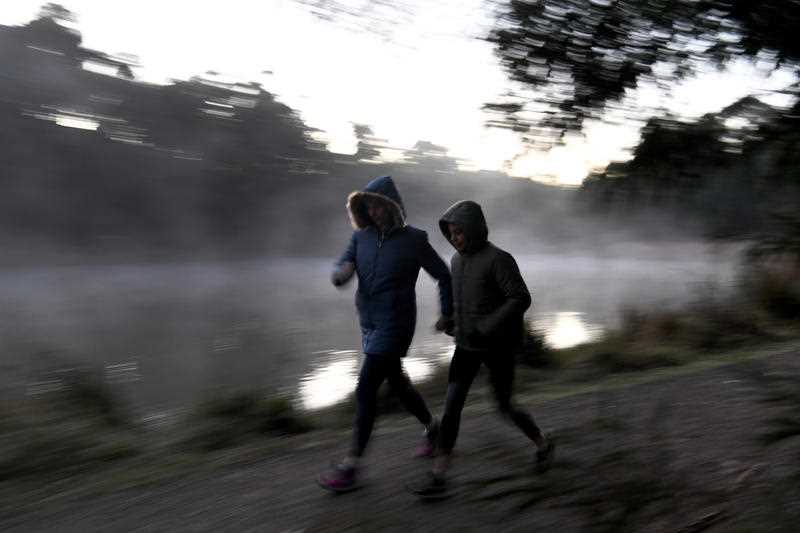 Two early walkers brave the cold weather at Birdsland reserve in Belgrave South, east of Melbourne.