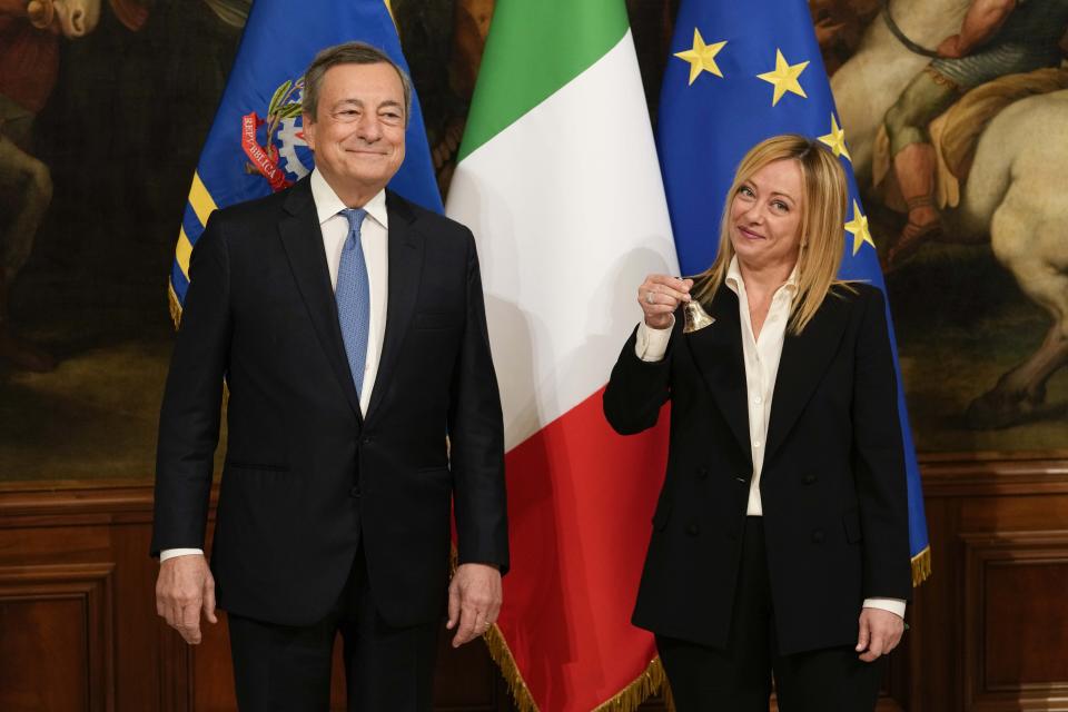 FILE - Newly appointed Italian Premier Giorgia Meloni, right, flanked by outgoing Premier Mario Draghi, holds the cabinet of minister's bell during the handover ceremony at Chigi Palace premier's office, in Rome, Sunday, Oct. 23, 2022. When Giorgia Meloni took office a year ago as the first far-right premier in Italy's post-war history, concern was palpable abroad about the prospect of democratic backsliding and resistance to European Union rules. But since being sworn in as premier on Oct. 22, 2022, Meloni has confounded Western skeptics. (AP Photo/Andrew Medichini, File)