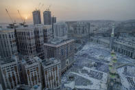 The sun sets over the city of Mecca as Muslim pilgrims wait to offer evening prayers inside the Grand Mosque, ahead of the annual Hajj pilgrimage, in the Muslim holy city of Mecca, Saudi Arabia, Friday, Aug. 17, 2018. The annual Islamic pilgrimage draws millions of visitors each year, making it the largest yearly gathering of people in the world. (AP Photo/Dar Yasin)