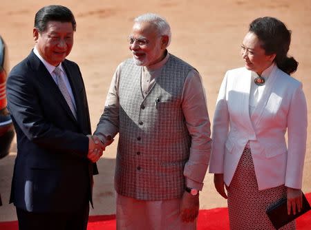 India's Prime Minister Narendra Modi (C) and China's President Xi Jinping shake hands as Xi's wife Peng Liyuan (R) looks on during Xi’s ceremonial reception at the forecourt of India's Rashtrapati Bhavan presidential palace in New Delhi September 18, 2014. REUTERS/Ahmad Masood