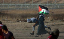 A female demonstrator runs for cover during a protest where Palestinians demand the right to return to their homeland, at the Israel-Gaza border in the southern Gaza Strip May 25, 2018. REUTERS/Ibraheem Abu Mustafa