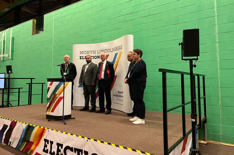 The candidates at the count lining up for the declaration, where Labour's Sir Nic Dakin, centre with red rosette and tie, was announced as the winner