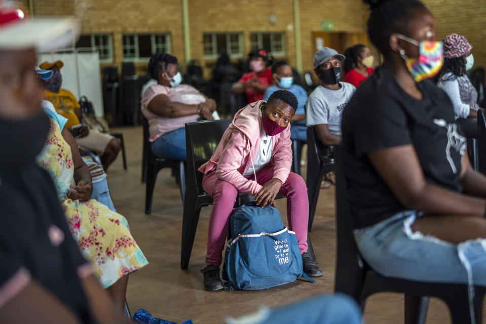 People who just received their jab against COVID-19 Friday Dec. 3, 2021 wait for their vaccine card to be processed at the Orange Farm, South Africa, multipurpose center. South Africa has accelerated its vaccination campaign a week after the discovery of the omicron variant of the coronavirus. (AP Photo/Jerome Delay)