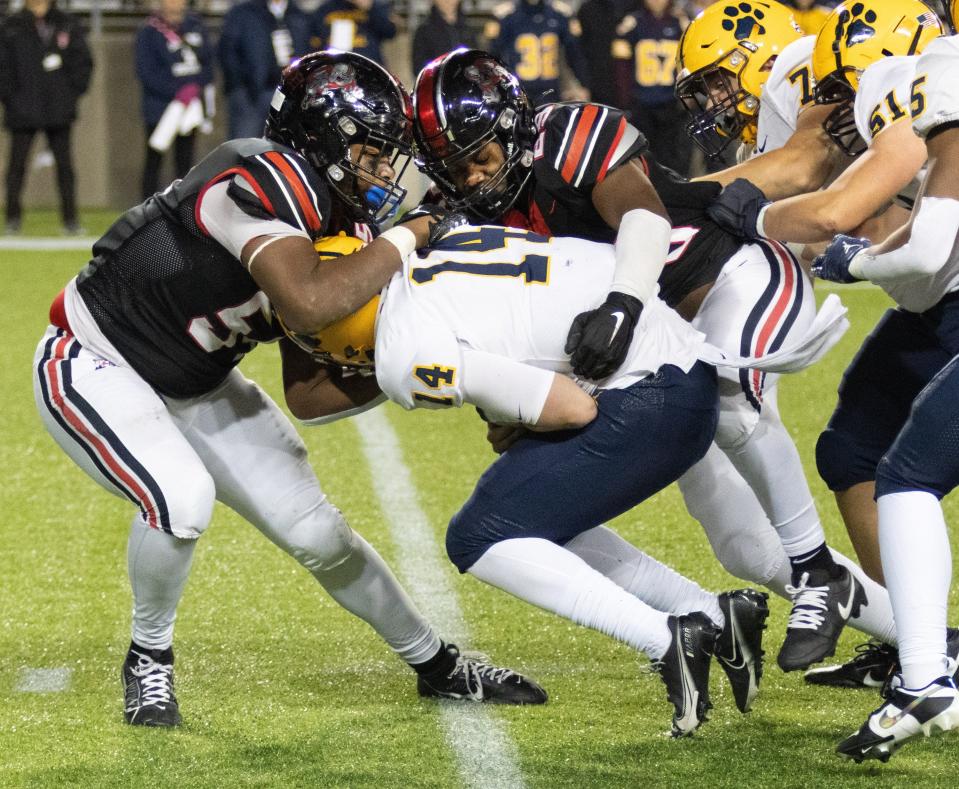 McKinley’s Dior Darner (left) and Braylon Minor sack St. Ignatius quarterback Joshua Papesh on Friday, Nov. 3, 2023.