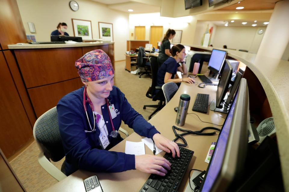 Hannah Pecora, RN, prepares dishcharge papers for a patient at SSM St. Agnes Hospital earlier this year. Pecora lost all her hair during the peak of COVID. It has never grown back.