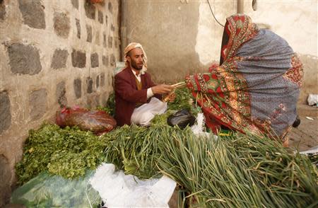 A veil-clad woman buys vegetables in Old Sanaa city November 11, 2013. REUTERS/Khaled Abdullah