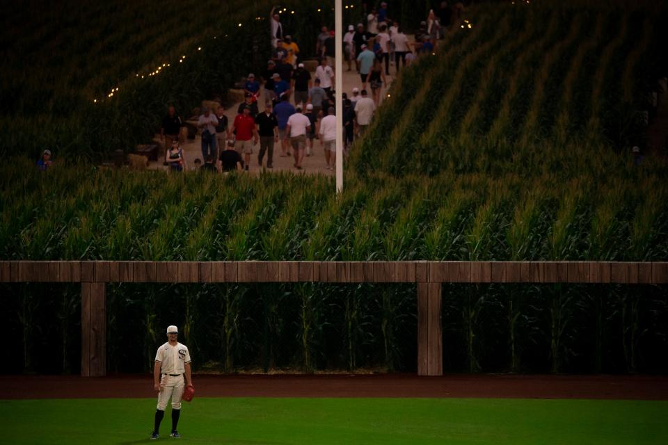 The Chicago White Sox's Adam Engel waits for the next play as fans walk to the "Field of Dreams" movie site during the 2021 game against the New York Yankees near Dyersville, Iowa.