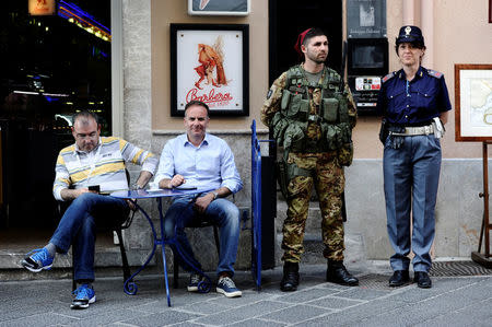 An Italian Army soldier and a policewoman patrol in Taormina where leaders from the world's major Western powers will hold their annual summit, Italy, May 24, 2017. REUTERS/Guglielmo Mangiapane