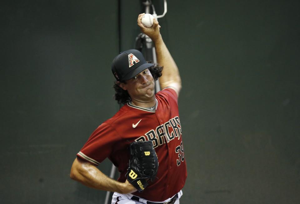 Arizona Diamondbacks starting pitcher Robbie Ray warms up in the bullpen during team baseball practice at Chase Field, Friday, July 3, 2020, in Phoenix. (AP Photo/Ross D. Franklin)