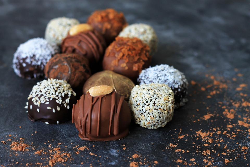 Homemade chocolate candies for Valentine's Day on dark table background.