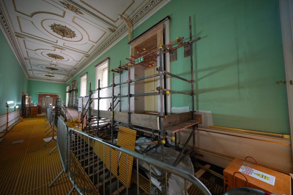 Scaffolding and building materials inside a mint-green painted hallway during Buckingham Palace's East Wing refurbishment, on June 21, 2021.