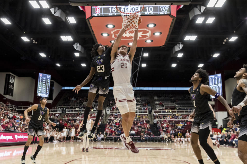 Washington guard Keyon Menifield, center left, and Stanford forward Brandon Angel, center right, battle for a rebound during the first half of an NCAA college basketball game in Stanford, Calif., Sunday, Feb. 26, 2023. (AP Photo/John Hefti)
