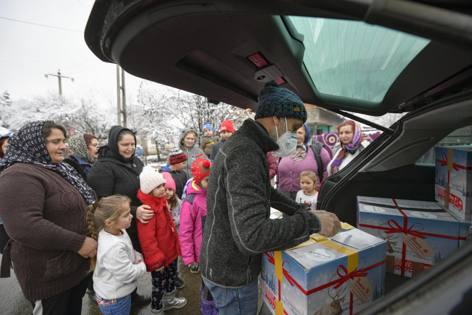 Valeriu Nicolae distributes boxes containing basic food, hygiene and medicinal products in Leresti, Romania, Saturday, Jan. 9, 2021. Nicolae and his team visited villages at the foot of the Carpathian mountains, northwest of Bucharest, to deliver aid. The rights activist has earned praise for his tireless campaign to change for the better the lives of the Balkan country’s poorest and underprivileged residents, particularly the children. (AP Photo/Andreea Alexandru)