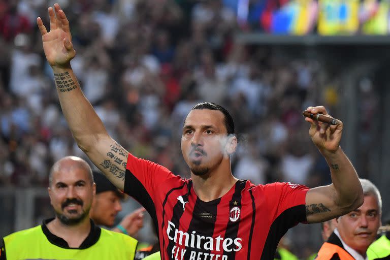 AC Milan's Swedish forward Zlatan Ibrahimovic smokes a cigar during the winner's trophy ceremony after AC Milan won the Italian Serie A football match between Sassuolo and AC Milan, securing the 