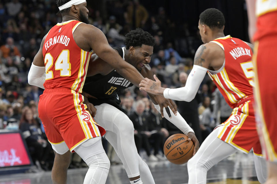 Memphis Grizzlies forward Jaren Jackson Jr. (13) works between Atlanta Hawks forward Bruno Fernando (24) and guard Dejounte Murray (5) during the second half of an NBA basketball game Friday, March 8, 2024, in Memphis, Tenn. (AP Photo/Brandon Dill)