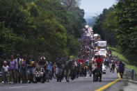 Migrants walk along the highway toward the municipality of Escuintla, Chiapas state, Mexico, early Thursday, Oct. 28, 2021, as they continue their journey toward the northern states of Mexico and the U.S. border. (AP Photo/Marco Ugarte)