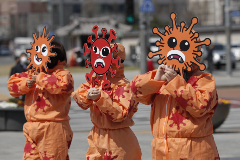 Environmental activists wearing masks symbolizing a virus perform during a new coronavirus prevention campaign in Seoul, South Korea, Monday, March 30, 2020. The new coronavirus causes mild or moderate symptoms for most people, but for some, especially older adults and people with existing health problems, it can cause more severe illness or death. (AP Photo/Lee Jin-man)