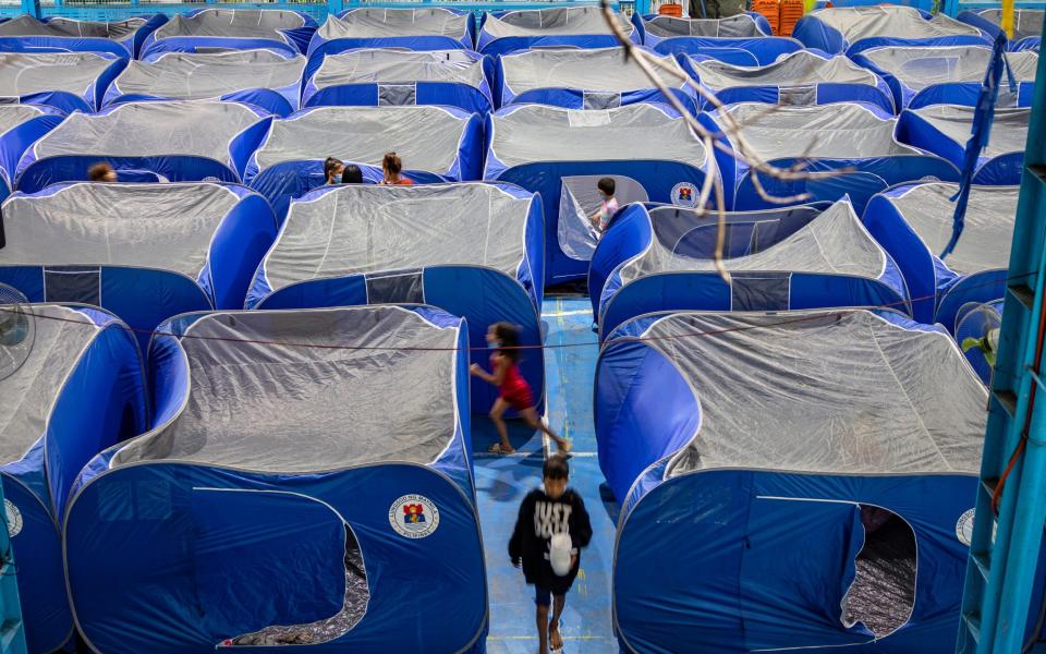 Filipinos take shelter in tents inside a school gymnasium converted into an evacuation centre - Ezra Acayan/Getty