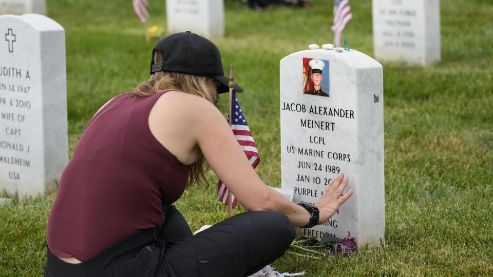 Krista Meinert touches the headstone of her son in Arlington National Cemetery on Memorial Day. Marine Lance Cpl. Jacob Alexander Meinert, of Fort Atkinson, Wisconsin, was with 1st Battalion, 3rd Marine Regiment, 3rd Marine Division, when he stepped on a landmine in Helmand  province, Afghanistan, Jan. 10, 2010. (Alex Brandon/AP)