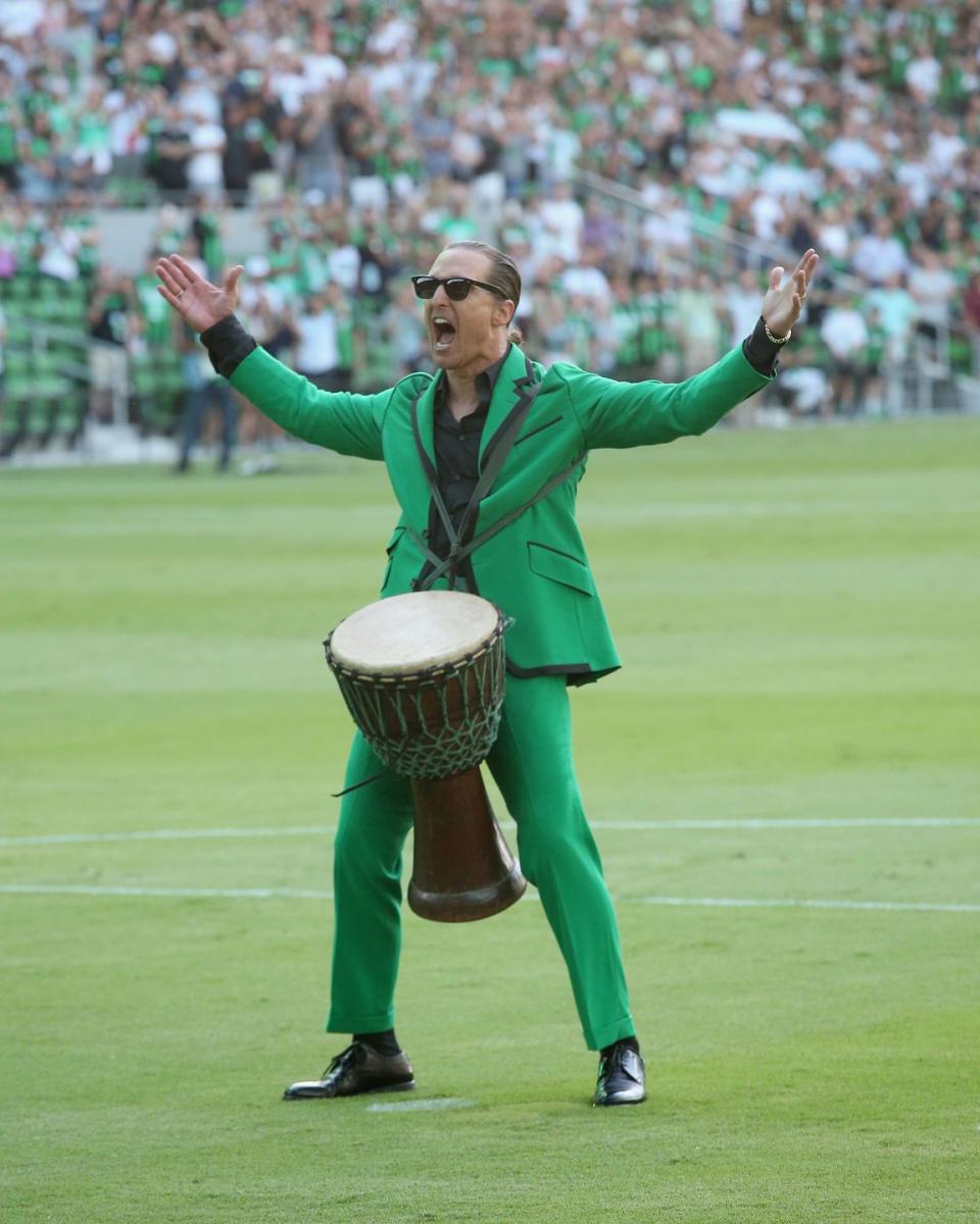 matthew mcconaughey screaming at the crowd while banging on a drum