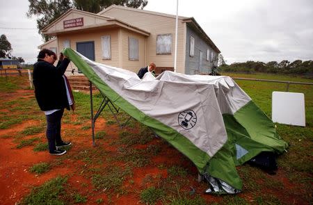 Team leader Kelly-Anne Mackay is assisted by Heather McInerney as they assemble a remote voting station in the western New South Wales outback town of Enngonia, Australia, June 22, 2016. REUTERS/David Gray