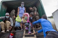 A Honduran migrant child is helped off a Guatemalan army truck after being returned to El Florido, Guatemala, one of the border points between Guatemala and Honduras, Tuesday, Jan. 19, 2021. A once large caravan of Honduran migrants that pushed its way into Guatemala last week had dissipated by Tuesday in the face of Guatemalan security forces. (AP Photo/Oliver de Ros)