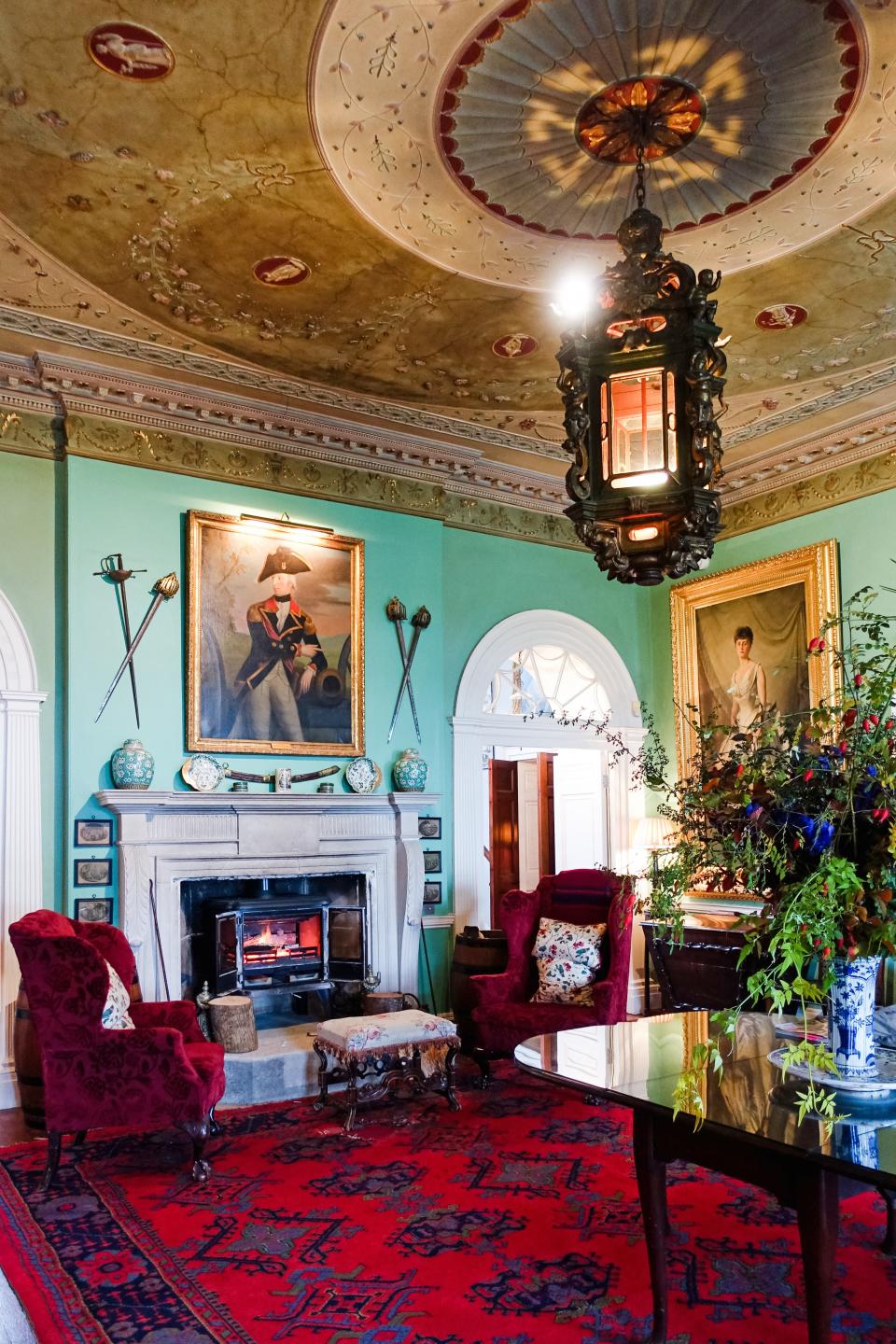 The mint-colored hall is furnished with historic objects that resonate with the mansion's character.