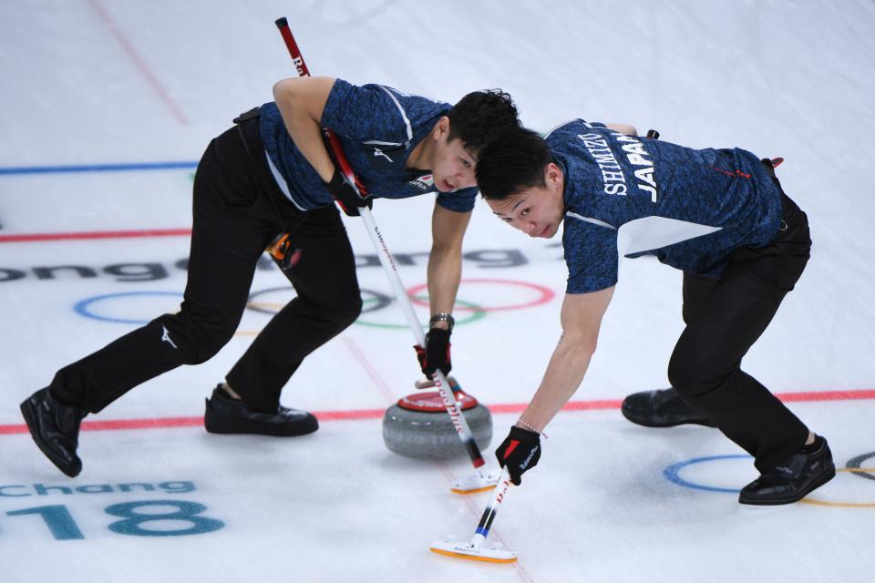 <p>Japan’s Tetsuro Shimizu (R) brushes in front of the stone during the curling men’s round robin session between Japan and Italy during the Pyeongchang 2018 Winter Olympic Games at the Gangneung Curling Centre in Gangneung on February 17, 2018 </p>