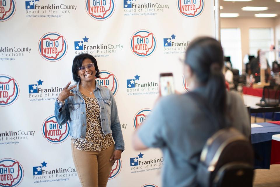 Lee Penn of East Columbus, has her picture taken on the first day of early voting for Issue 1 on Tuesday at the Franklin County Board of Elections. Penn says she has a tradition of early voting on the first day of every election and remarked that this was the busiest she has seen it.