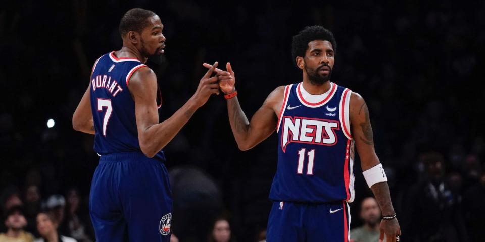 Kevin Durant and Kyrie Irving high-five during a Nets game in 2022.