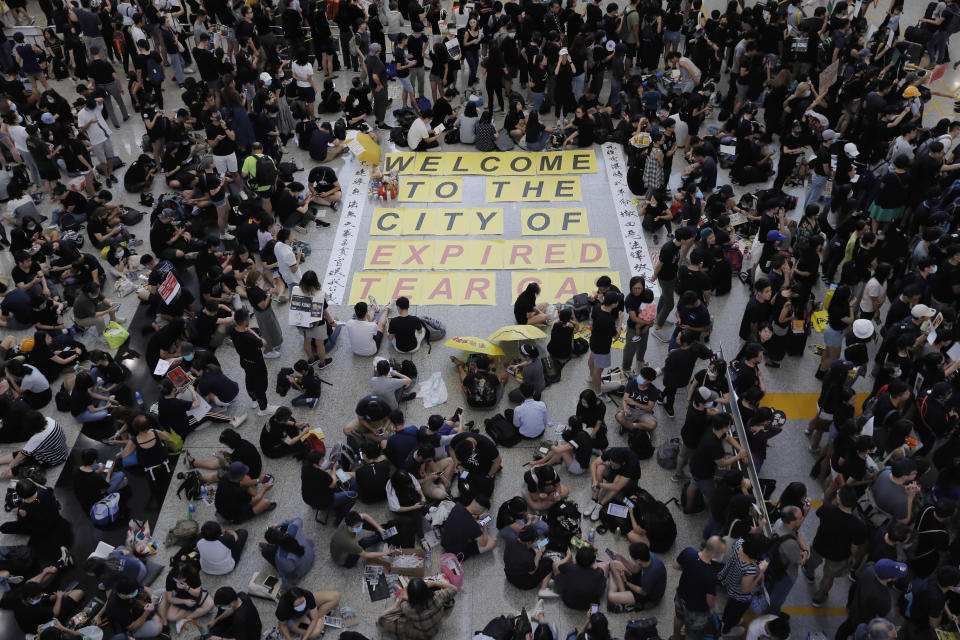 Thousands take part in a second day of sit-in protest at the airport in Hong Kong on Saturday, Aug. 10, 2019. Hong Kong is in its ninth week of demonstrations that began in response to a proposed extradition law but have expanded to include other grievances and demands for more democratic freedoms. (AP Photo/Kin Cheung)