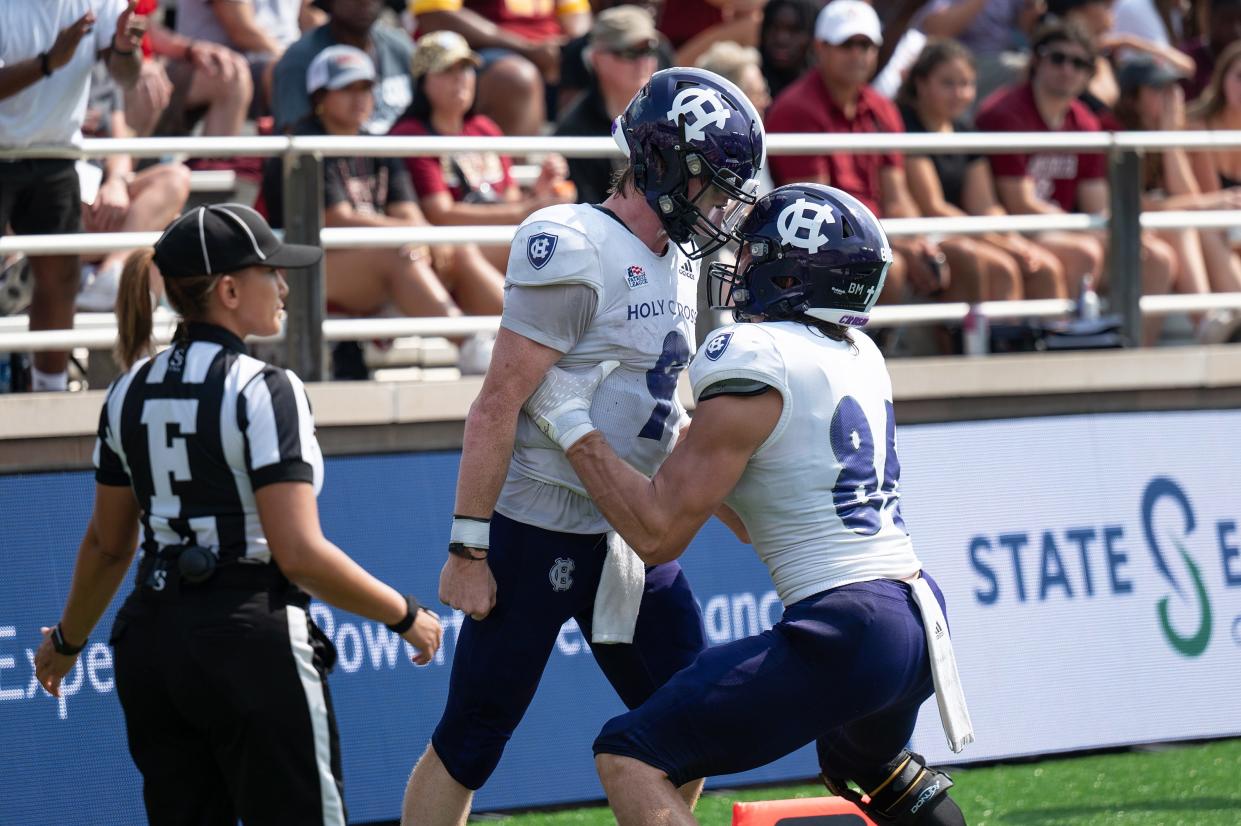 Holy Cross’s Matthew Sluka, left, shown celebrating a touchdown run with teammate Jacob Peterson against Boston College last season, is in the final stages of finishing up his degree.