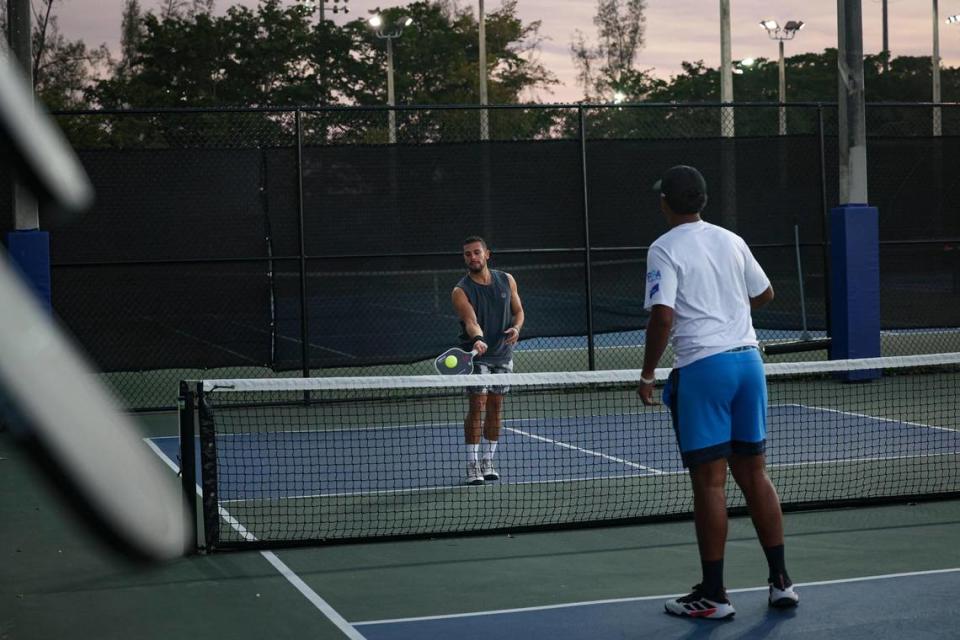 Mario Figueredo, left, a professional pickleball player, volleys back and forth with Dom Geminiani at Tropical Park courts on Monday, Feb. 13, 2023, in Miami.