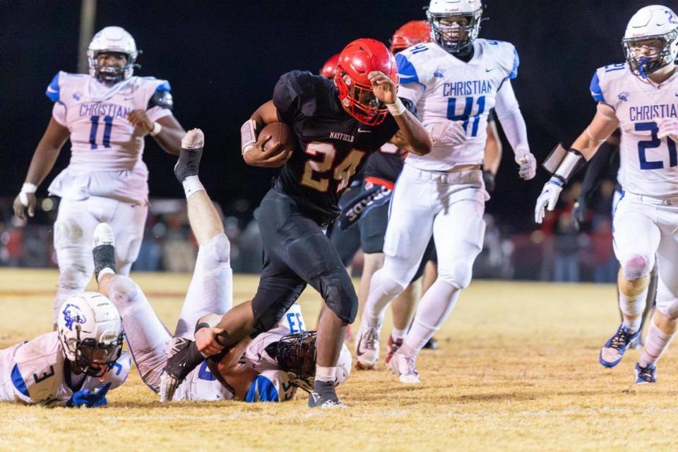 Mayfield’s Jutoriaus “JuJu” Starks (24) runs the ball past Lexington Christian’s Braylon Moss (3) and Mac Darland (33) during their region championship game at War Memorial Stadium in Mayfield on Nov. 17.