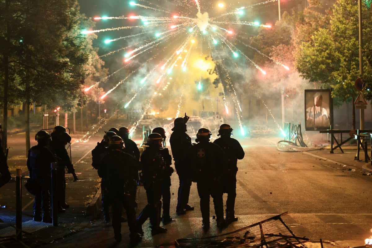 Police stand amid firecrackers on the third night of protests (Copyright 2023 The Associated Press. All rights reserved.)
