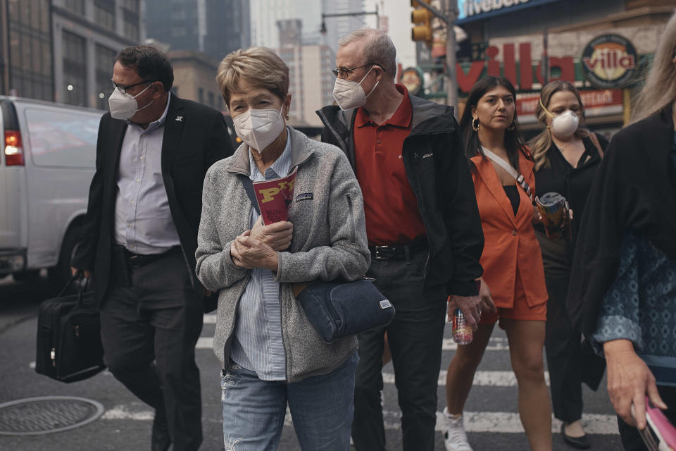 People walk wearing masks as an air quality health advisory from wildfire was issued in New York on Wednesday, June 7, 2023. (AP Photo/Andres Kudacki).