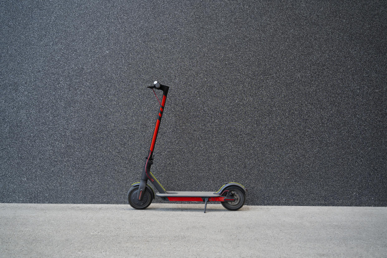 E scooter next to black modern wall, no people