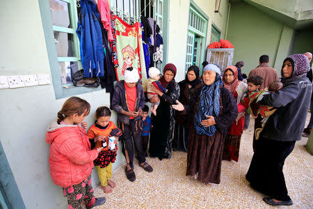 Displaced Iraqi women with children who fled their homes during a battle between Iraqi forces and Islamic State militants, gather at a Mosque in Hammam al-Alil, south of Mosul, Iraq, March 20, 2017. REUTERS/Thaier Al-Sudani