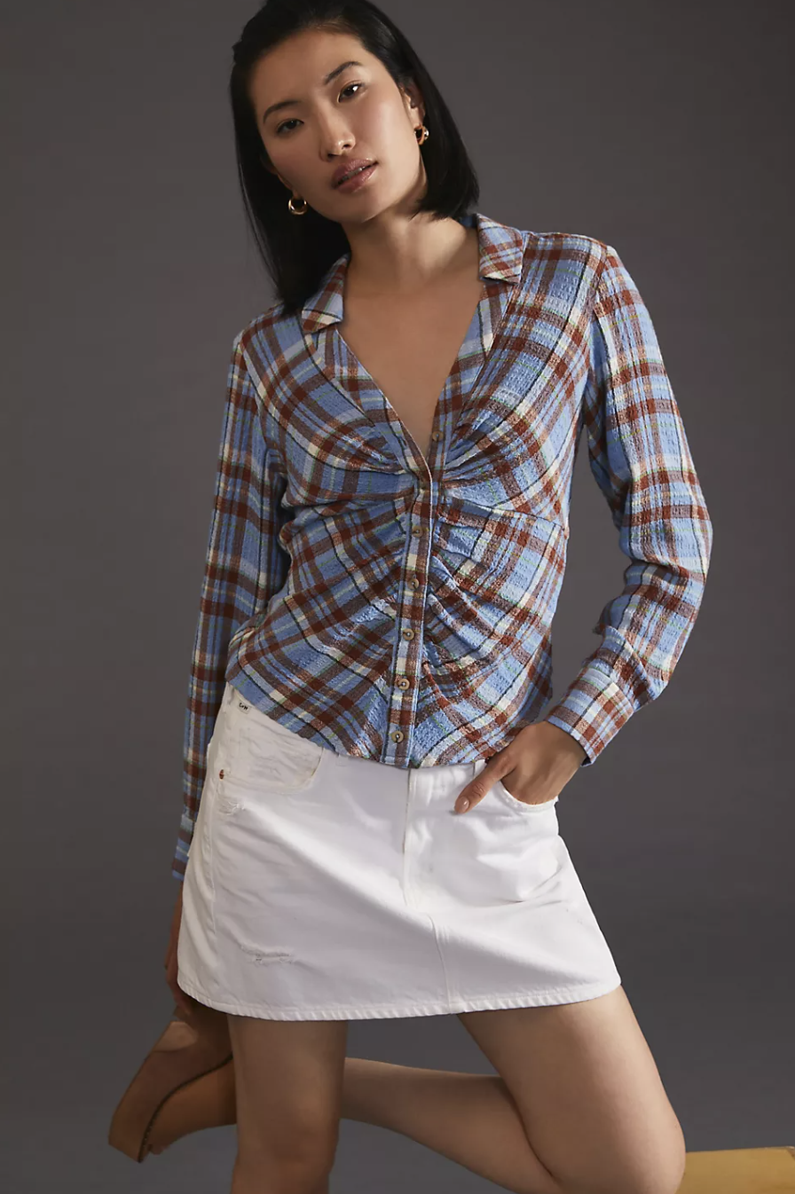 model in white skirt and blue checked shirt Pilcro Ruched Shirt (Photo via Anthropologie)