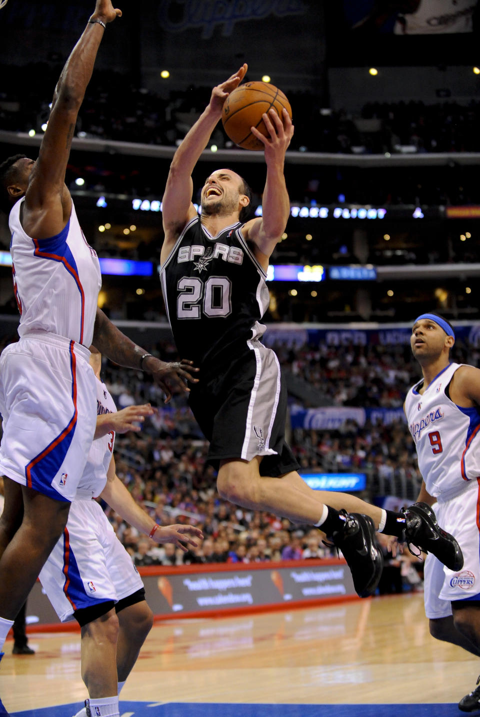 San Antonio Spurs guard Manu Ginobili (20), of Argentina, drives on Los Angeles Clippers center DeAndre Jordan, left, for a basket in the first half of a NBA basketball game, Tuesday, Feb. 18, 2014, in Los Angeles.(AP Photo/Gus Ruelas)