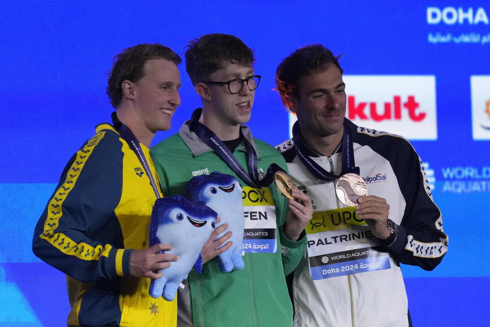 Gold medalist Daniel Wiffen of Ireland, center, silver medalist Elijah Winnington of Australia and bronze medalist Gregorio Paltrinieri of Italy pose for a photo during the medal ceremony for the men's 800-meter freestyle final at the World Aquatics Championships in Doha, Qatar, Wednesday, Feb. 14, 2024. (AP Photo/Lee Jin-man)