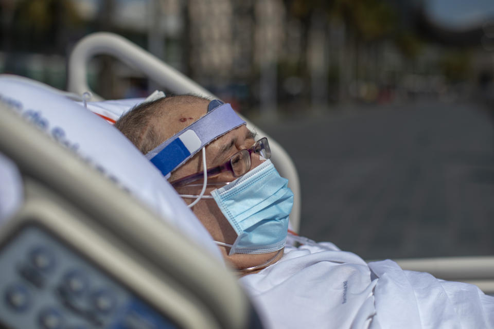 Francisco España, 60, looks at the Mediterranean sea from a promenade next to the "Hospital del Mar" in Barcelona, Spain, Friday, Sept. 4, 2020. A hospital in Barcelona is studying how short trips to the beach may help COVID-19 patients recover from long and traumatic intensive hospital care. The study is part of a program to “humanize” ICUs. Since re-starting it in early June, the researchers have anecdotally noticed that even ten minutes in front of the blue sea waters can improve a patient’s emotional attitude. (AP Photo/Emilio Morenatti)